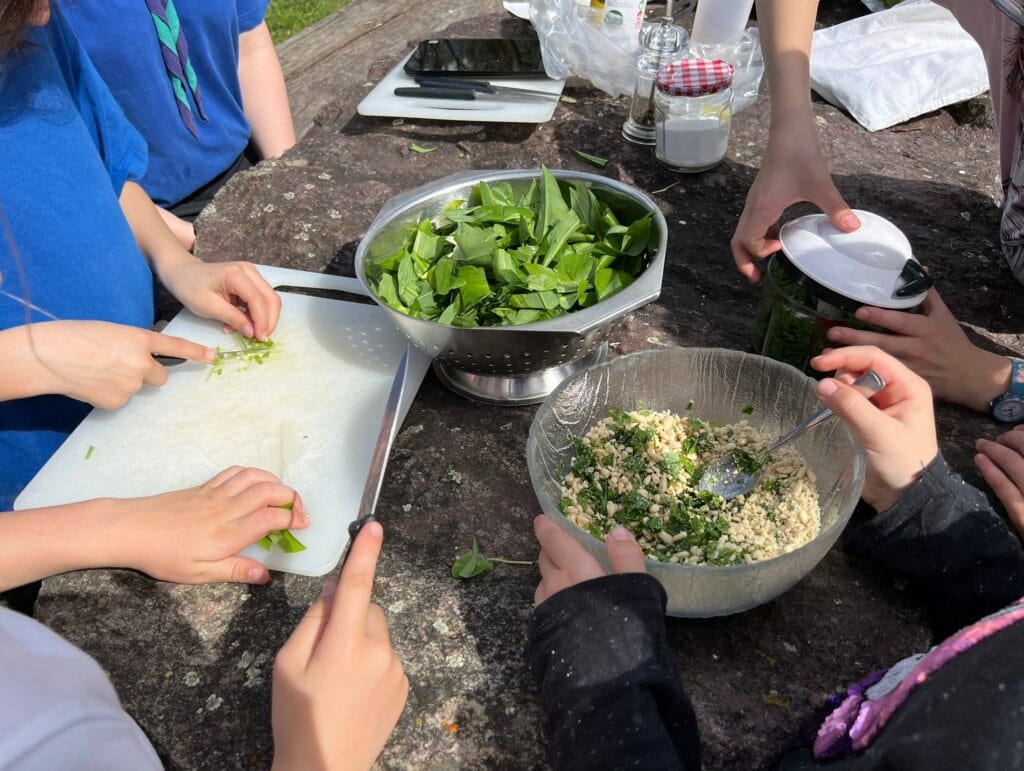 Das Bild zeigt, wie ein paar kleine Pfadfinder selbst eine Bärlauch-Pesto im Wald zubereiten.