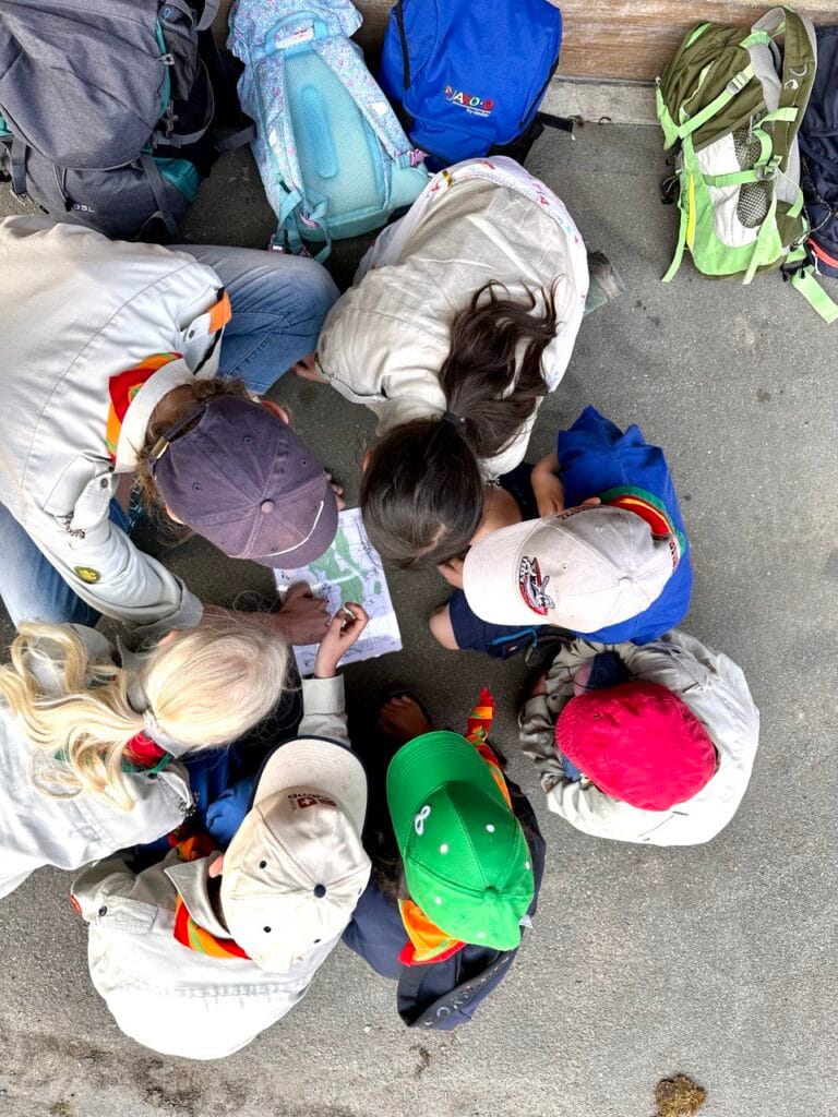 Dieses Bild zeigt eine Gruppe von Pfadfindern, die gemeinsam eine Landkarte lesen.